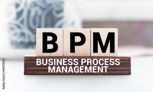 Acronym BPM, Business process management. Wooden small cubes with letters on financial documents