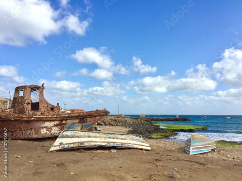 A closeup of old rusty boats turned upside downon the shore photo