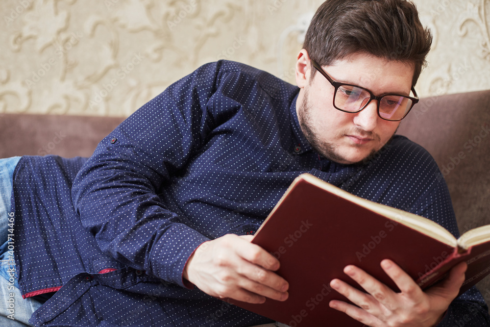 caucasian man with glasses reading a book, copy space caucasian man with glasses reading a book, copy space