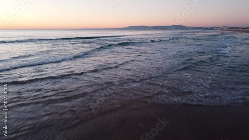 Low Flying Shot of Waves during Sunset at Costa da Caparica beach, Portugal photo