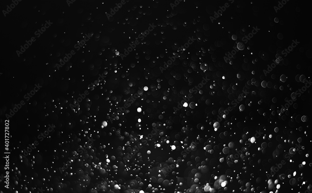 Glitter lights abstract background. Defocused bokeh on dark or black background.