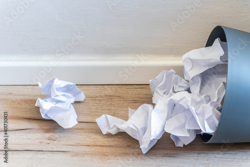 Paper trash. crumple paper falling to the recycling bin, Was thrown to basket bin, Overflowing waste paper in office garbage bin old wooden background side view with copy space. High quality photo