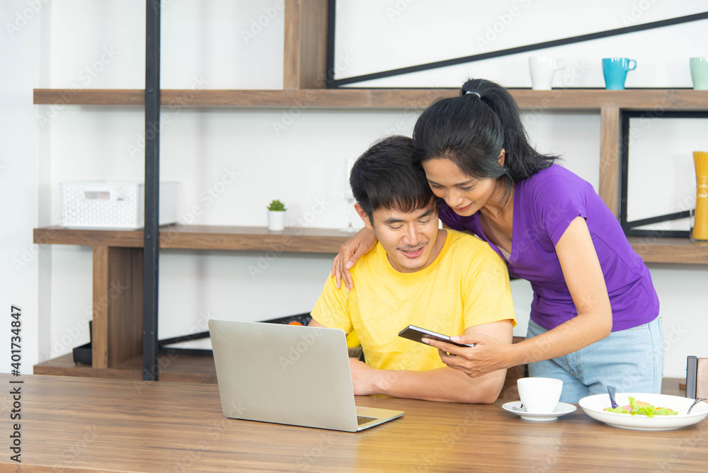 Happy and funny family. Asian lovely couple, beautiful woman and handsome man is having breakfast, talking in the kitchen Happy and funny family. Asian lovely couple, beautiful woman and handsome man is having breakfast, talking in the kitchen