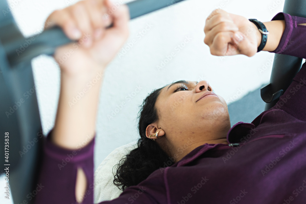 Fototapeta premium A woman looking at her watch in the gym