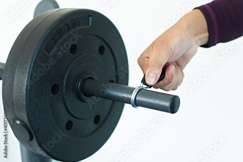 A hand holding the weight bench clamp