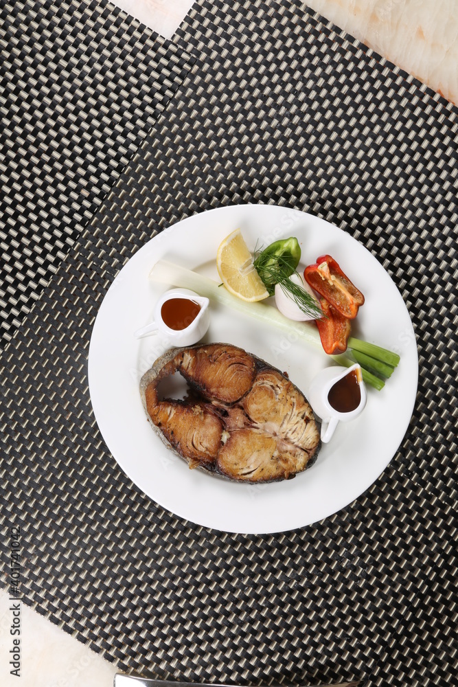 Deep oil fried fish slice served with vegetable and sauces slices lemon Deep oil fried fish slice served with vegetable and sauces slices lemon