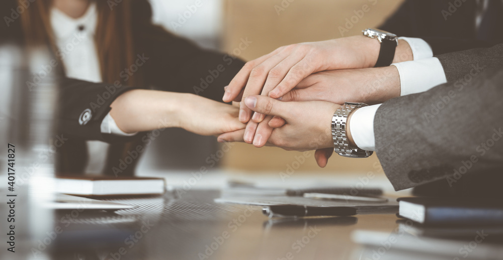 Unknown business people group joining hands in modern office. Businessmen and women making circle with their hands as a team, close-up Unknown business people group joining hands in modern office. Businessmen and women making circle with their hands as a team, close-up