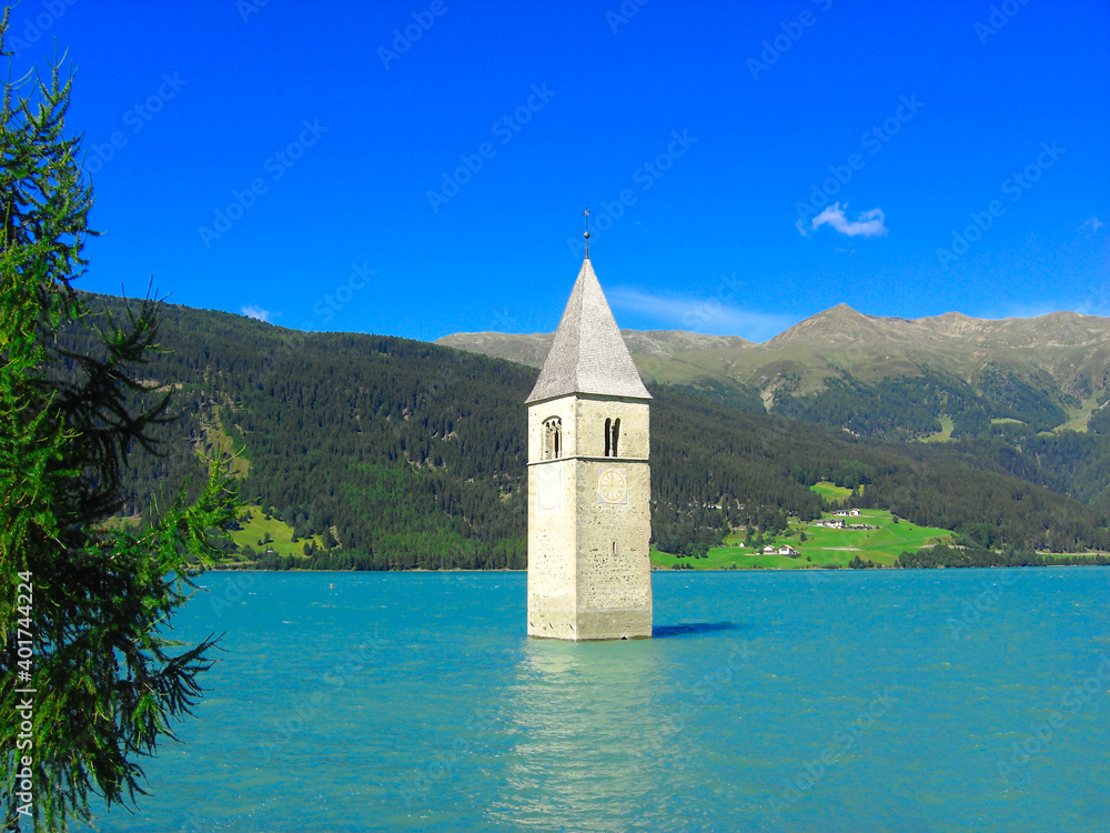 View of the lake Resia. perfect blue sky over the azure water in lake. Bell tower of the Reschensee South Tyrol, Italy.