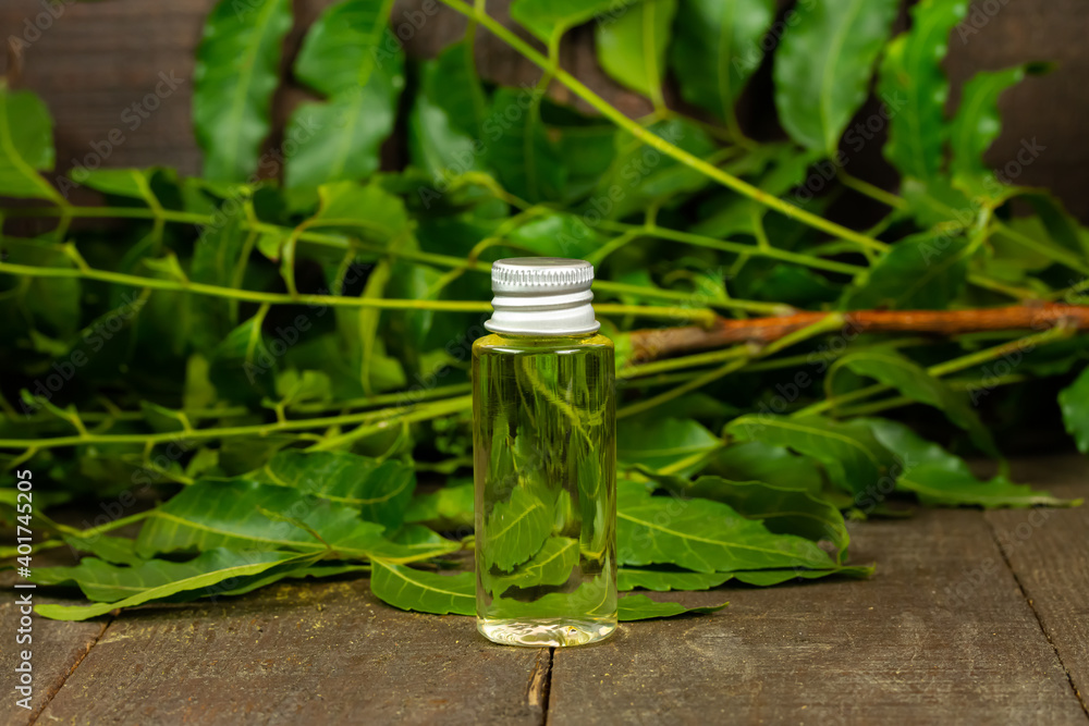 neem oil in bottle and neem leaf on wooden background. neem oil in bottle and neem leaf on wooden background.