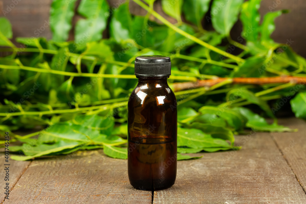 neem oil in bottle and neem leaf on wooden background. neem oil in bottle and neem leaf on wooden background.
