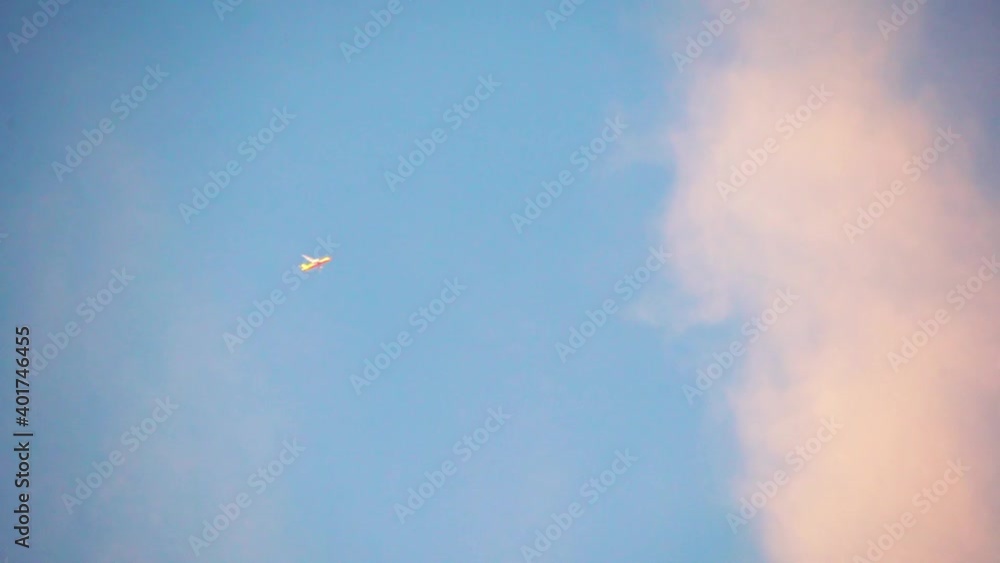commercial aeroplane flying with clouds in the sky at dusk dawn as commercial flights open up after the pandemic shot in slow motion with sunlight glinting off the plane for a dreamy look commercial aeroplane flying with clouds in the sky at dusk dawn as commercial flights open up after the pandemic shot in slow motion with sunlight glinting off the plane for a dreamy look