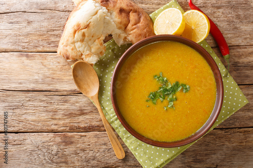 Shorbat adas is a vegan lentil soup from Middle East closeup in the bowl on the table. Horizontal top view above photo