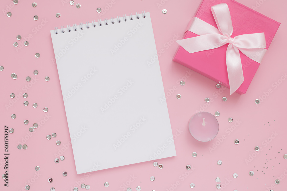 White blank notepad sheet, pink candle, gift box and confetti on pink background, Happy Valentine's Day White blank notepad sheet, pink candle, gift box and confetti on pink background, Happy Valentine's Day