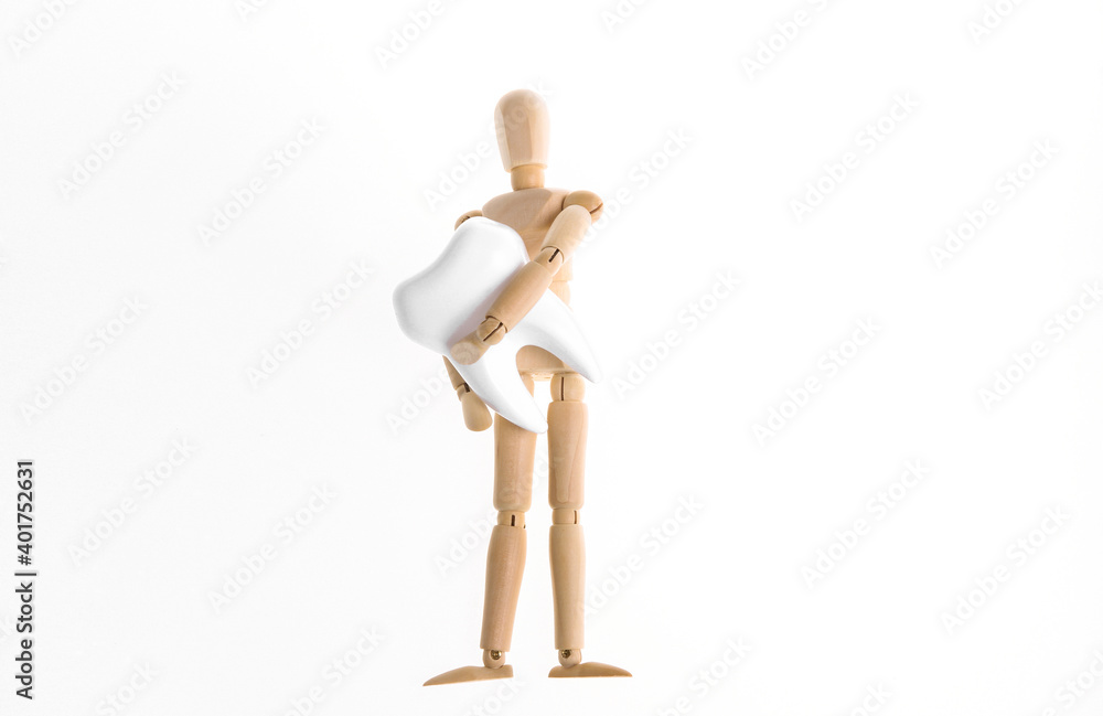 Wooden puppet holding tooth isolated on white background Wooden puppet holding tooth isolated on white background