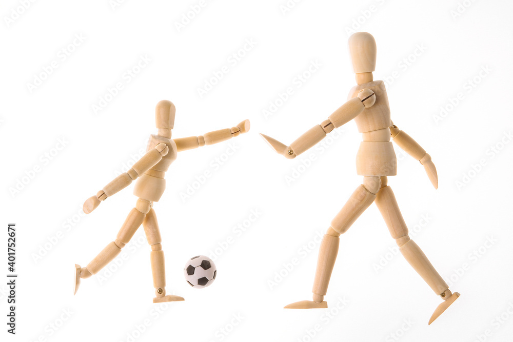 Wooden puppets dummy playing soccer isolated on white background Wooden puppets dummy playing soccer isolated on white background