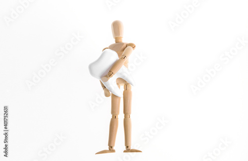 Wooden puppet holding tooth isolated on white background