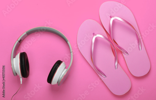 Travel, vacation on the beach concept. Flip flops and headphones on a pink background. Top view.