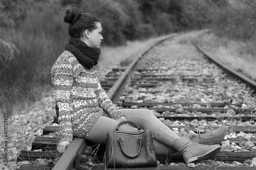 Young woman sitting on the railroad tracks photo