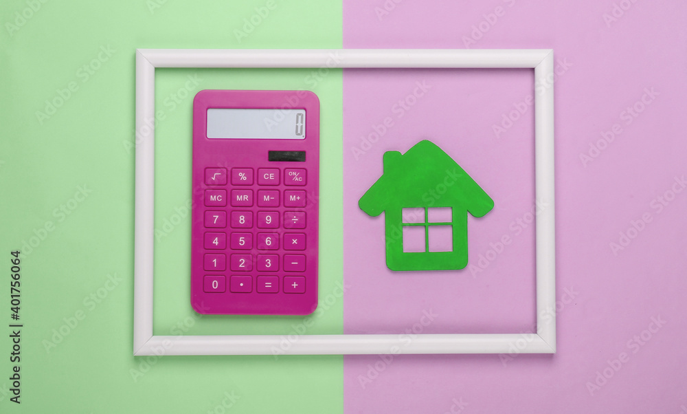Calculator and green house in a white frame on pink green background. Concept art photo. Top view. Minimalism Calculator and green house in a white frame on pink green background. Concept art photo. Top view. Minimalism