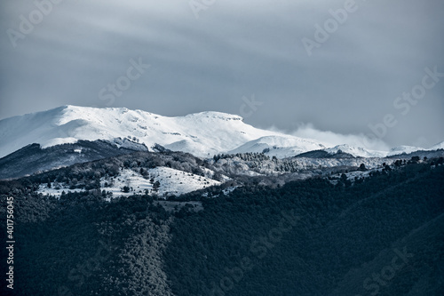 View from above, stunning panoramic view of a snow capped mountain range during a cloudy day. Italy. © Travel Wild