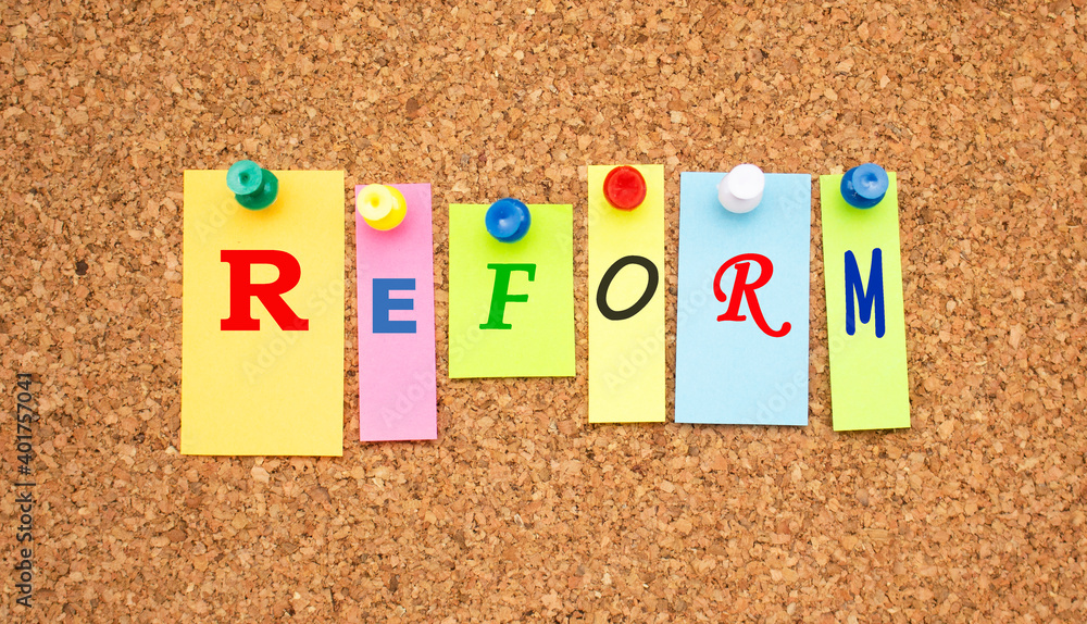 Color notes with letters pinned on a board. Word REFORM.