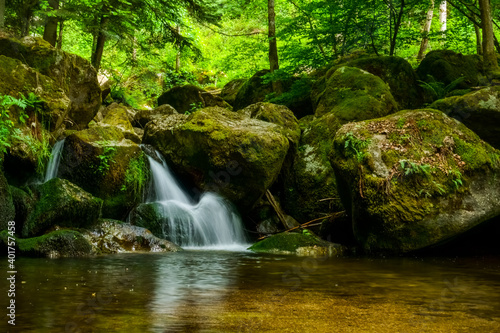 Fototapeta Naklejka Na Ścianę i Meble -  beautiful little waterfall flows in a shallow water