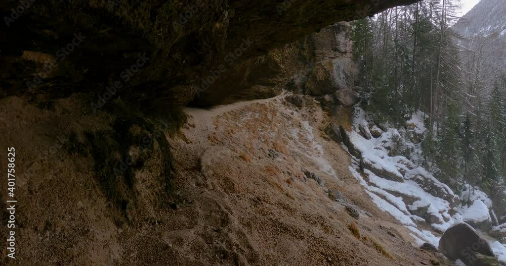 View under famous landmark waterfall Pericnik in Slovenia. Winter season in Alpine valley. Alps mountains covered with snow. Path under the cliff. Tilt up, real time, wide angle View under famous landmark waterfall Pericnik in Slovenia. Winter season in Alpine valley. Alps mountains covered with snow. Path under the cliff. Tilt up, real time, wide angle