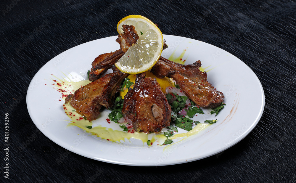 Grilled Lamb Chops with Cranberries and Rosemary on Natural Black Stone Background. Roasted Cutlets on Creative Restaurant Backdrop. Mutton Ribs with Spices and Sause Grilled Lamb Chops with Cranberries and Rosemary on Natural Black Stone Background. Roasted Cutlets on Creative Restaurant Backdrop. Mutton Ribs with Spices and Sause