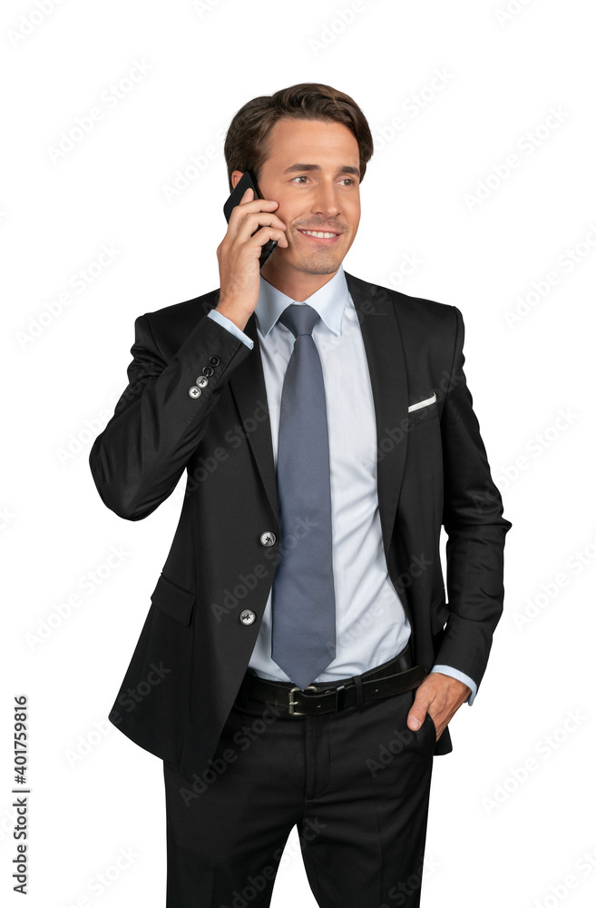 Businessman in black suit, blue shirt and tie talking on the phone, isolated over white background. Caucasian manager smiling standing with phone, hand in the pocket Businessman in black suit, blue shirt and tie talking on the phone, isolated over white background. Caucasian manager smiling standing with phone, hand in the pocket