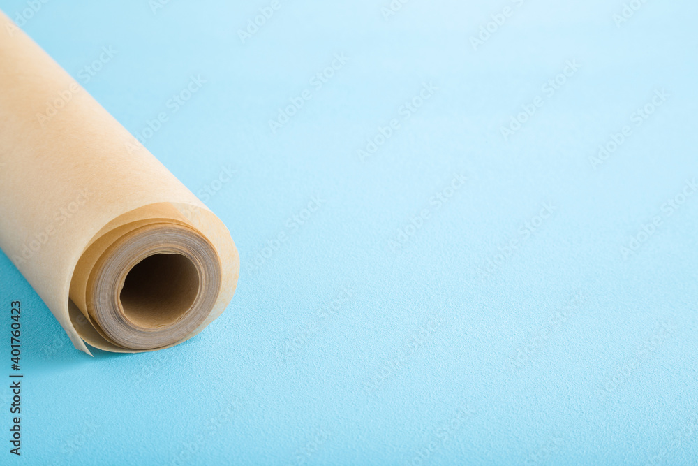 Roll of baking paper on light blue table background. Pastel color. Closeup. Empty place for text. Roll of baking paper on light blue table background. Pastel color. Closeup. Empty place for text.