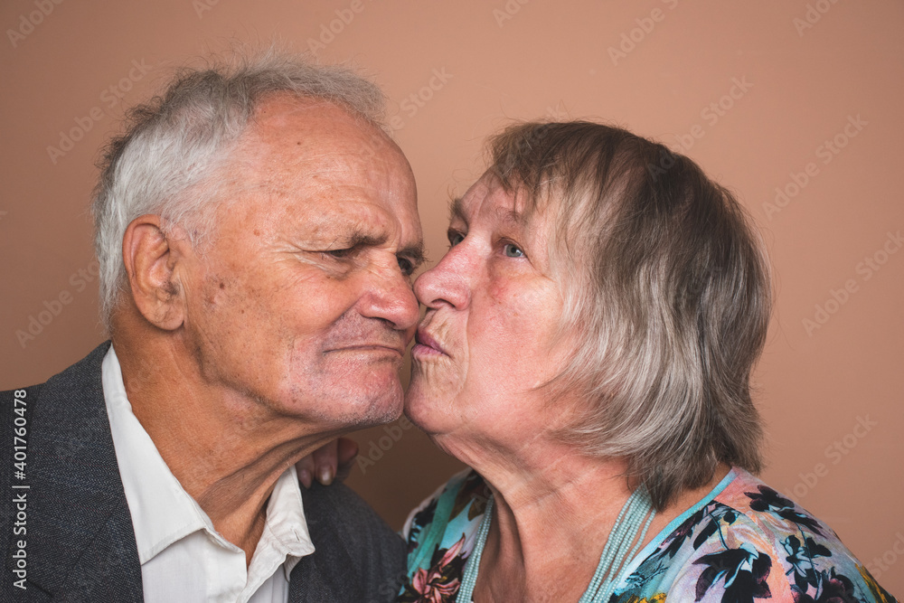 Portrait of adorable senior couple of pensioners in love; wife and husband kissing Portrait of adorable senior couple of pensioners in love; wife and husband kissing