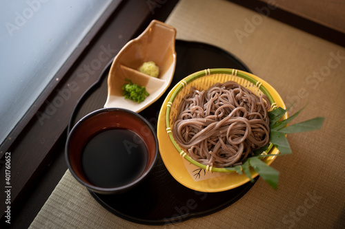 Cold soba Japanese noodle with black salt on the dark tray in Japanese restaurant 