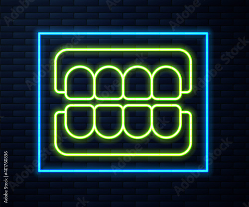 Glowing neon line False jaw icon isolated on brick wall background. Dental jaw or dentures, false teeth with incisors. Vector.