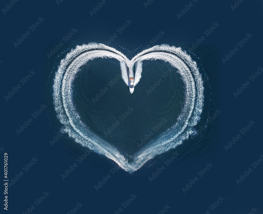 one boat form a shape of a heart on the ocean surface; aerial top down view