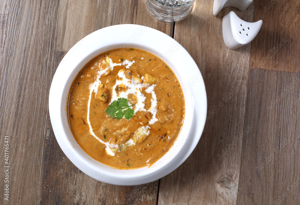 Alu Potato curry with cream North Indian Food in white bowl on wooden background Alu Potato curry with cream North Indian Food in white bowl on wooden background