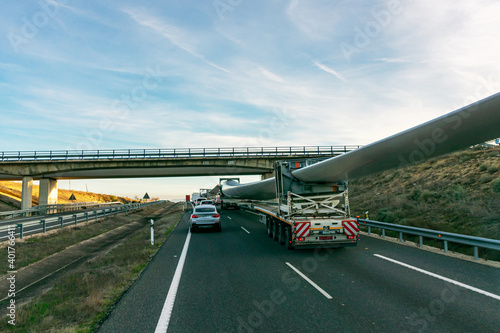 Special transport of blades for wind turbines  truck transporting a wind turbine blade that  due to its large size  requires a special adapted semi-trailer circulating on the highway and crossing unde