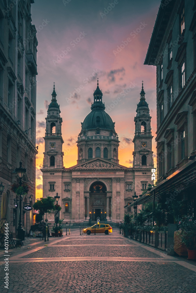 
St. Stephen's Basilica in Budapest Hungary. Beautiful sunrise at the church or cathedral in the middle of the city. Nice view through the street or square. backlit and old historical building
