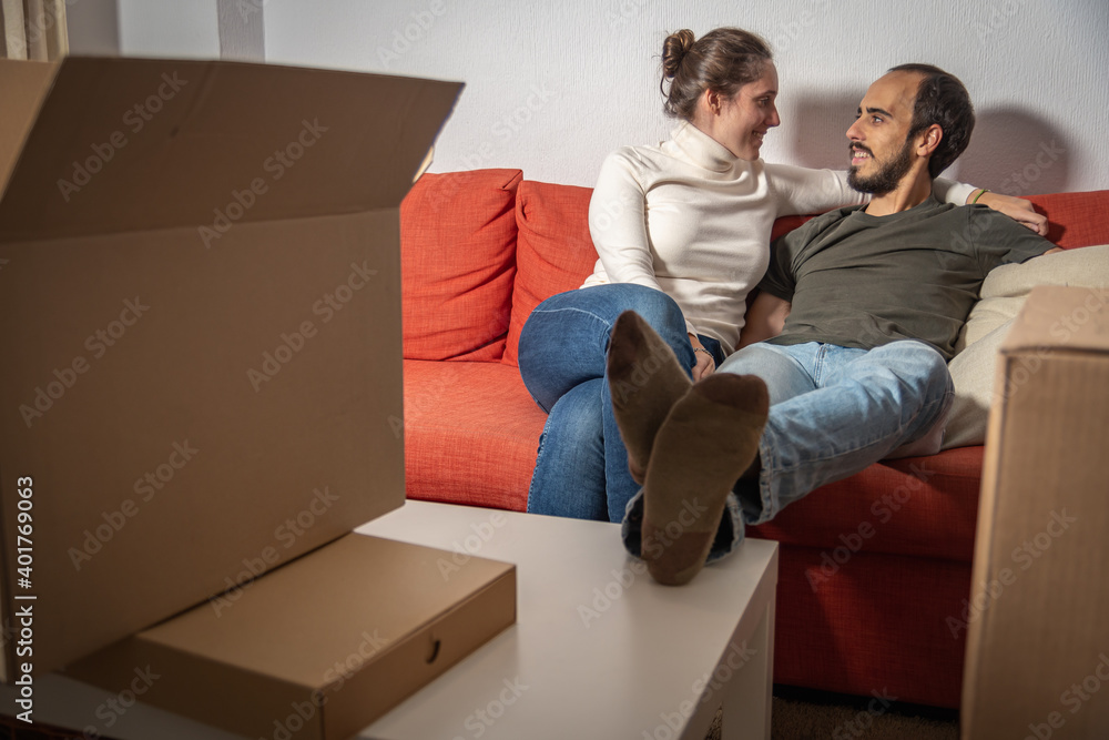 Happy couple having break during moving to new house Happy couple having break during moving to new house