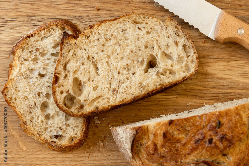 Fresh bread slice and cutting knife on rustic table. Fresh bread slice and cutting knife on rustic table.
