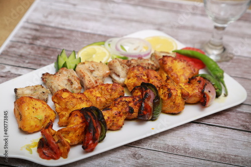Mix Kebab skewers Served with mint sauce wooden background with glass of water 