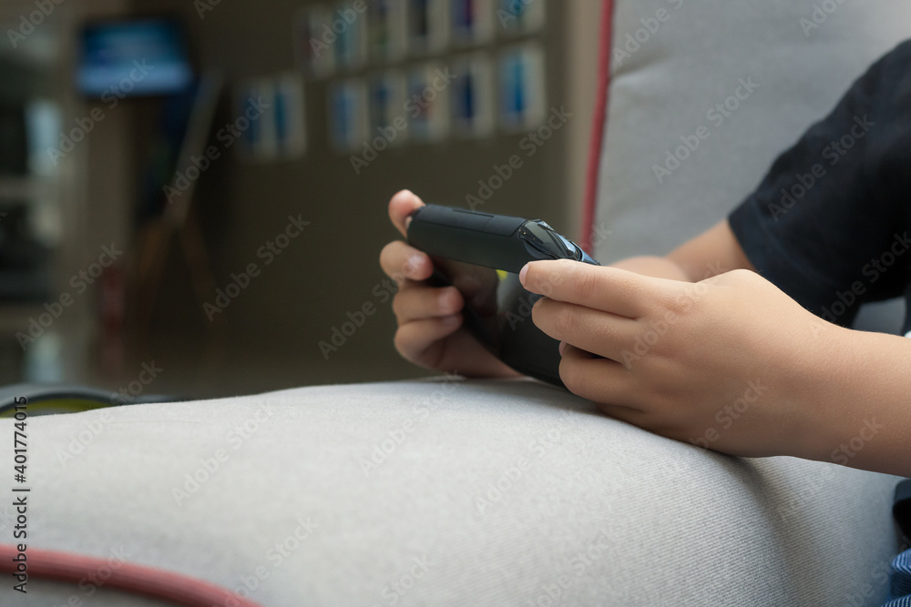 Close-up of kid playing video games at home.