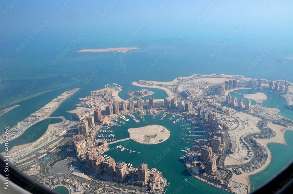 The Pearl-Qatar island in Doha through the airplane porthole, aerial view