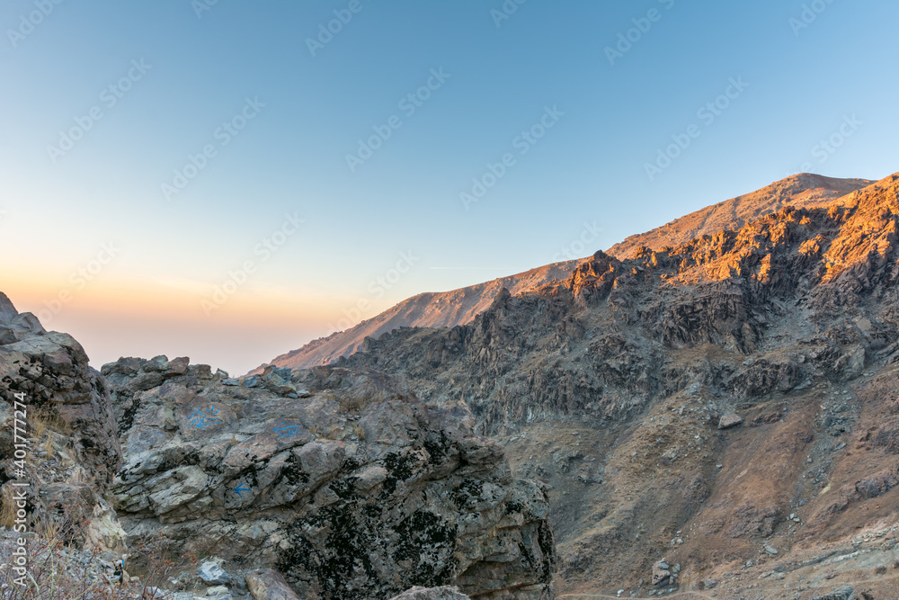 Barren mountain in Darband valley in dawn against colorful sky in the Tochal mountain with background of Tehran city in the morning. A popular recreational region for Tehran's residents