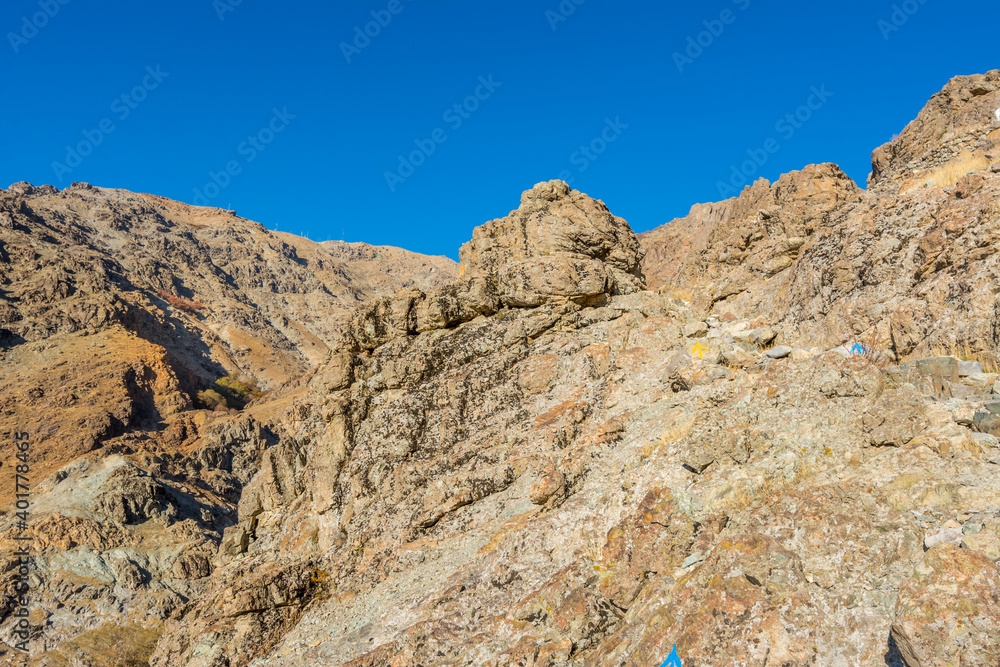 Fototapeta premium Barren mountain in Darband valley in autumn in the morning against blue sky in the Tochal mountain. A popular recreational region for Tehran's residents