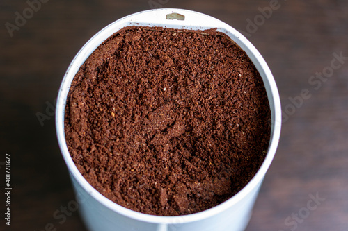 Roasted ground arabica beans in an electric coffee grinder.
