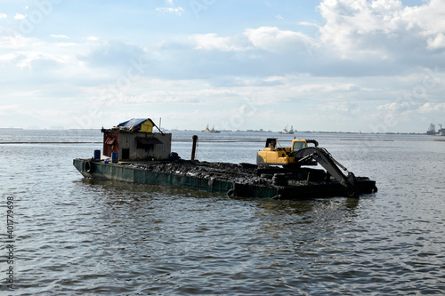 construction bulldozer crane truck working, loded on floating steel barge photo