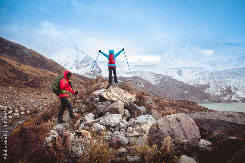 Two women hikers hiking  in winter mountains