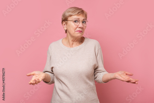 Obraz na płótnie Senior caucasian woman being clueless and confused with arms and hands raised