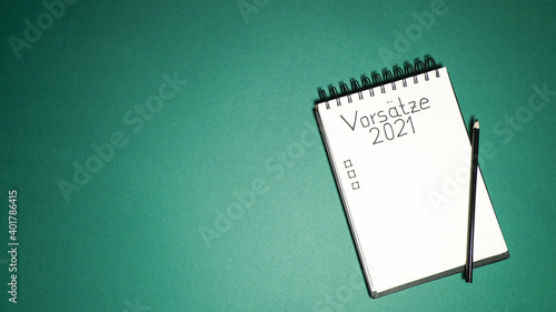 notebook with goal list 2021 green background Vorsätze  german language