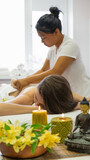 Young adult woman gets back massage at the beauty parlor